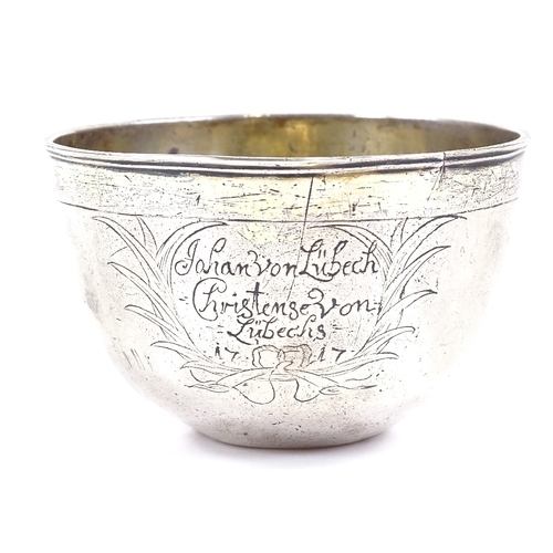 646 - An early 18th century German unmarked parcel gilt silver tumbler cup, relief embossed maiden playing... 