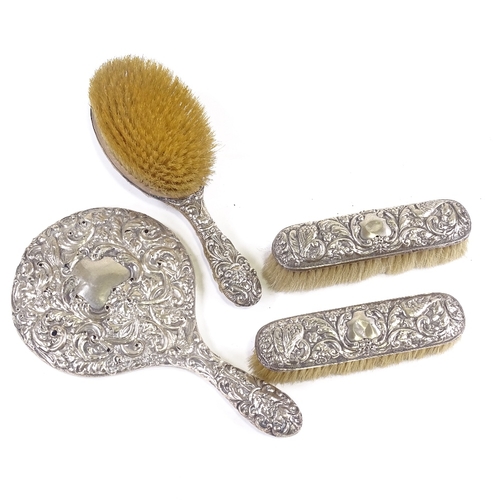 657 - An Edwardian 4-piece silver-backed dressing table set, comprising hand mirror, hand brush and pair o... 