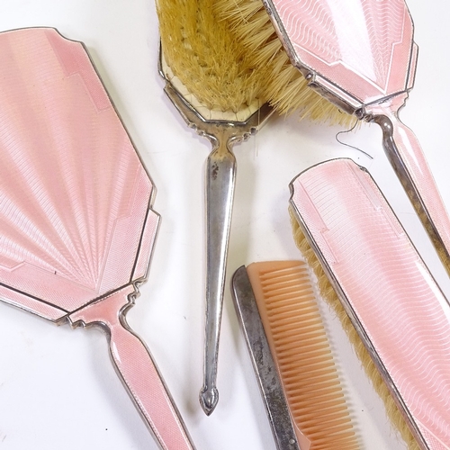 667 - An Art Deco 5-piece silver-back pink enamel dressing table set, comprising hand mirror, 2 hand brush... 