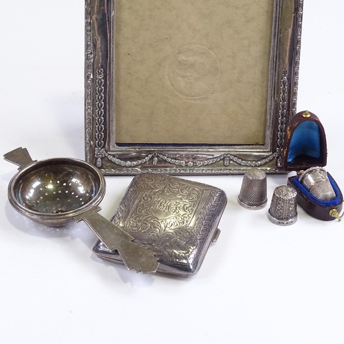 692 - Various silver, including photo frame, Art Deco tea strainer, cigarette case and thimbles (6)