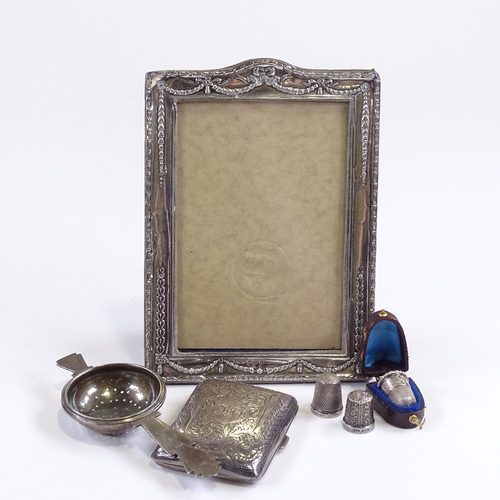 692 - Various silver, including photo frame, Art Deco tea strainer, cigarette case and thimbles (6)