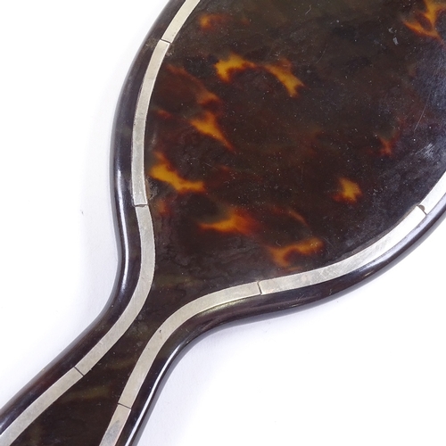 694 - An Edwardian tortoiseshell and silver inlaid dressing table hand mirror, overall length 26.5cm