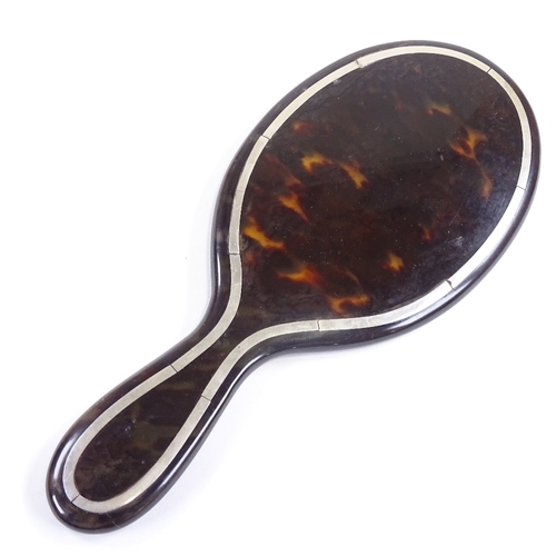 694 - An Edwardian tortoiseshell and silver inlaid dressing table hand mirror, overall length 26.5cm