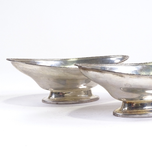 696 - A pair of George V silver boat-shaped pedestal bowls, engraved star rim, by Hukin & Heath, Jubilee h... 