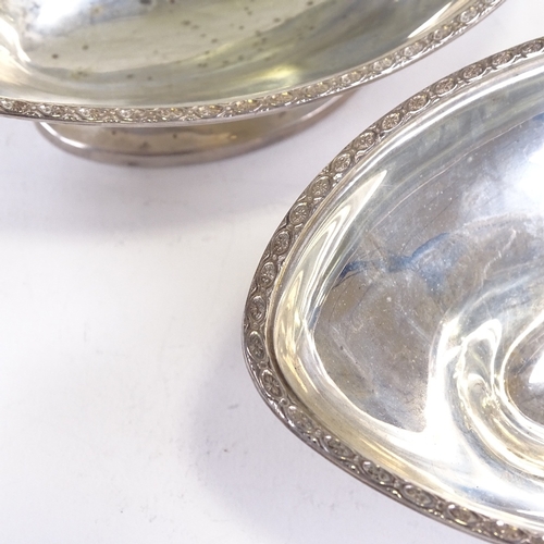 696 - A pair of George V silver boat-shaped pedestal bowls, engraved star rim, by Hukin & Heath, Jubilee h... 