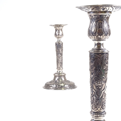 701 - A pair of 19th century German Hanau silver table candlesticks, allover engraved and embossed cherub ... 