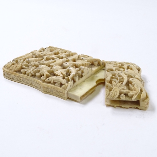 100 - A 19th century Chinese high relief carved ivory card case, the front depicting exotic birds and fish... 