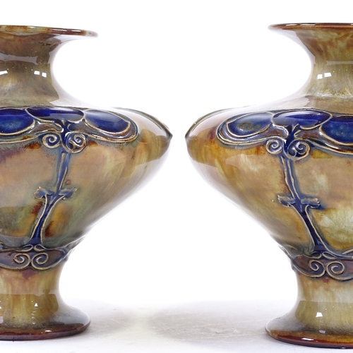 124 - A pair of Royal Doulton Art Nouveau stoneware vases, with relief stylised designs, pattern no. 120Y,... 