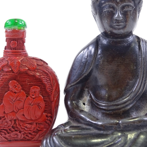 127 - A Chinese patinated spelter seated Buddha, height 10cm, a carved cinnabar snuff bottle, and a carved... 