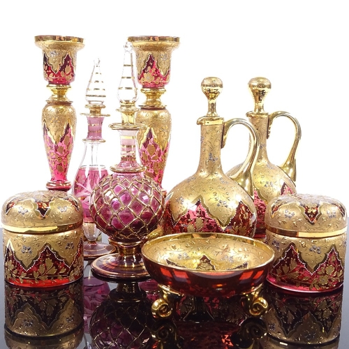 180 - A collection of mainly 19th century gilded Bohemian ruby glassware, including a pair of candlesticks... 