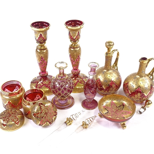 180 - A collection of mainly 19th century gilded Bohemian ruby glassware, including a pair of candlesticks... 