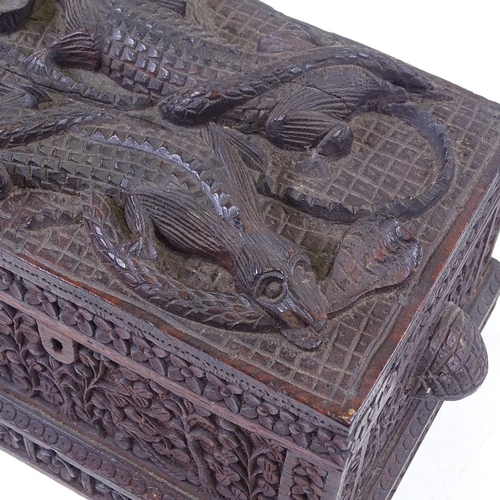 190 - An African or Asian carved wood box with relief carved cobra and crocodile decorated lid, length exc... 