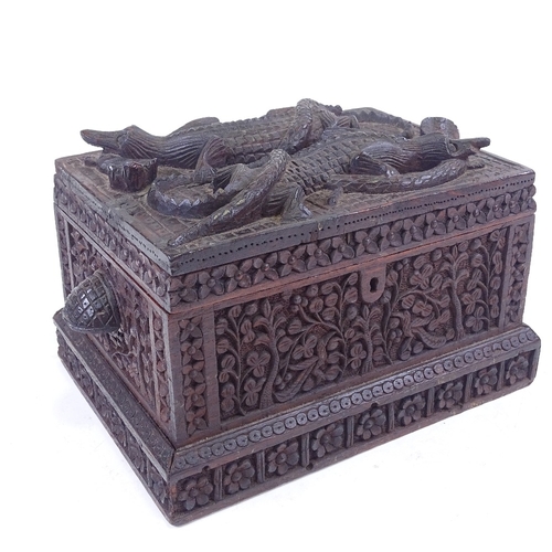 190 - An African or Asian carved wood box with relief carved cobra and crocodile decorated lid, length exc... 