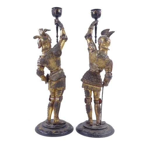 29 - A pair of Victorian painted and gilded spelter candle holders, supported by knights in armour, heigh... 