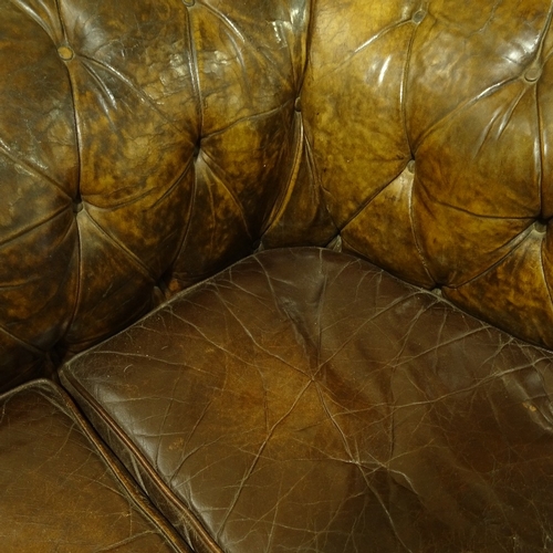 209 - A brown buttoned leather-upholstered 3-seater Club Chesterfield sofa, early 20th century, overall le... 