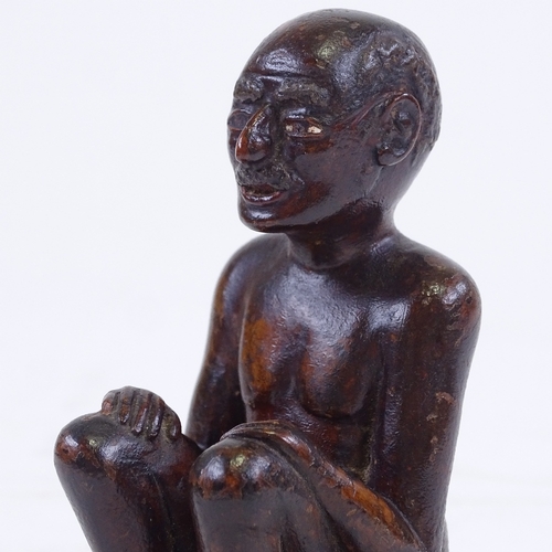 213 - An Indian 19th century wood carving of a seated man, height 9.5cm