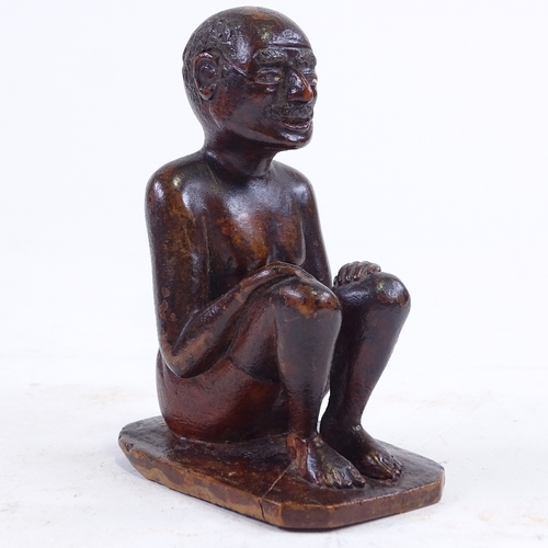 213 - An Indian 19th century wood carving of a seated man, height 9.5cm