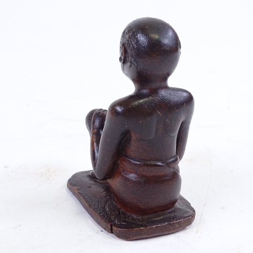 213 - An Indian 19th century wood carving of a seated man, height 9.5cm