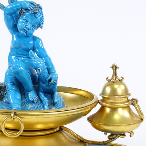 282 - An ornate 19th century French gilt-metal desk stand, surmounted by a blue glazed ceramic cherub and ... 