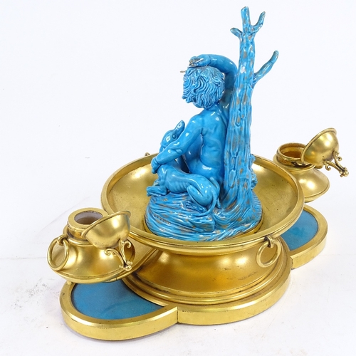 282 - An ornate 19th century French gilt-metal desk stand, surmounted by a blue glazed ceramic cherub and ... 