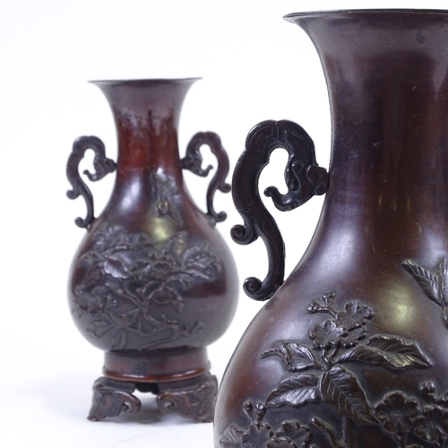 284 - A pair of Japanese 19th century patinated bronze vases, with relief moulded prunus decoration, on ca... 