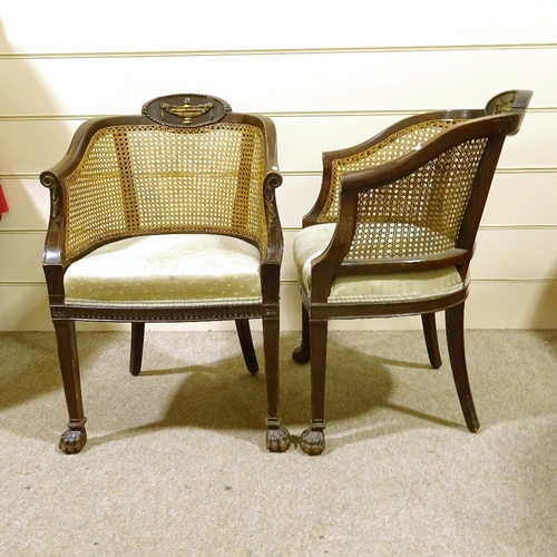 293 - A pair of early 20th century mahogany-framed bergere tub chairs, with cane-panelled backs and carved... 