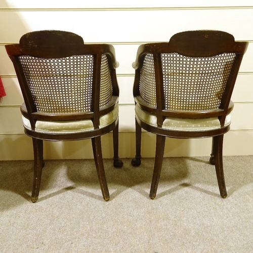 293 - A pair of early 20th century mahogany-framed bergere tub chairs, with cane-panelled backs and carved... 