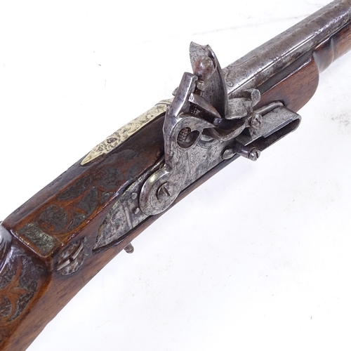 298 - An 18th century Middle Eastern flintlock rifle, with carved walnut stock and carved horn trigger pla... 