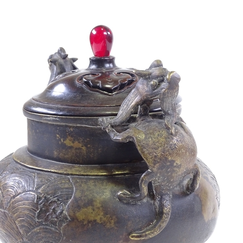 308 - A Chinese patinated bronze incense burner, with dragon cast handles and relief moulded side panels, ... 