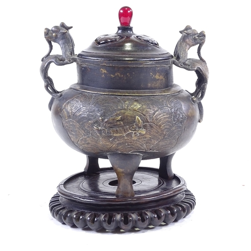 308 - A Chinese patinated bronze incense burner, with dragon cast handles and relief moulded side panels, ... 