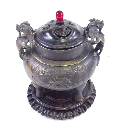 308 - A Chinese patinated bronze incense burner, with dragon cast handles and relief moulded side panels, ... 