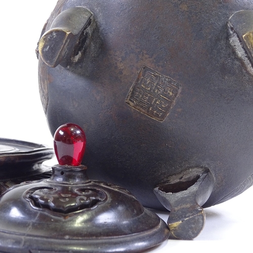 308 - A Chinese patinated bronze incense burner, with dragon cast handles and relief moulded side panels, ... 