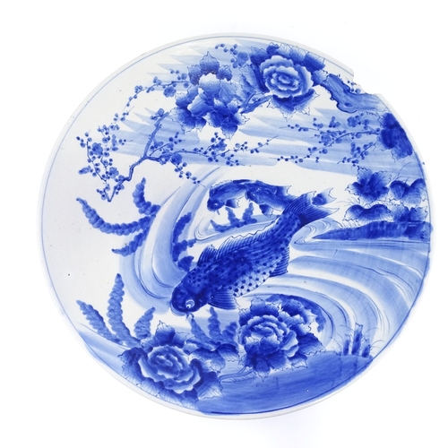 322 - A large Japanese blue and white porcelain charger, with hand painted carp design, diameter 61cm (A/F... 