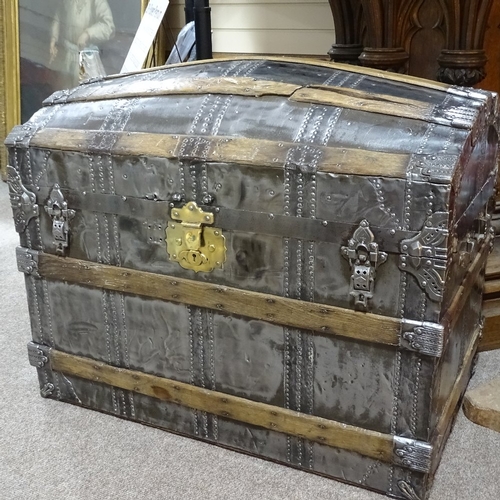 312 - A large Victorian polished metal and wood-bound dome-top travelling trunk with brass lock, length 93... 