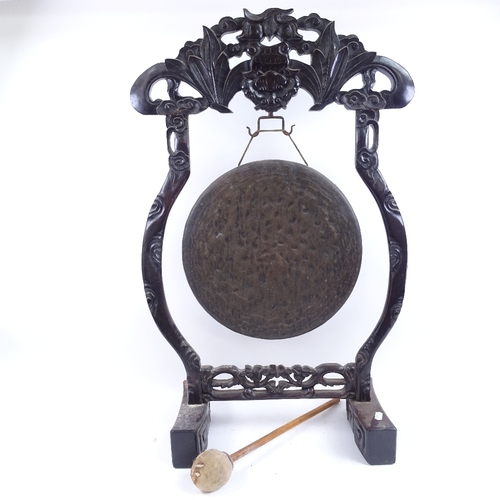 39 - A Chinese carved hardwood framed brass dinner gong, frame height 78cm
