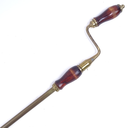 86 - A brass and turned wood handled rotary window opener, overall length 158cm