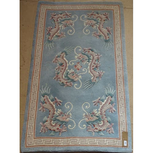 1854 - A Chinese design blue ground wool rug, with dragon decoration, 150cm x 95cm