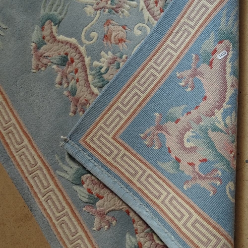 1854 - A Chinese design blue ground wool rug, with dragon decoration, 150cm x 95cm