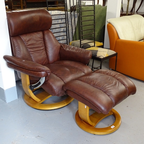 1849 - A Stressless style brown upholstered swivel armchair, with matching footstool