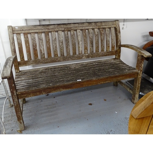 1820 - A slatted hardwood weathered garden bench, W139cm