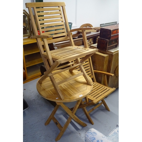 1827 - A teak circular folding garden table, and a pair of matching folding teak chairs