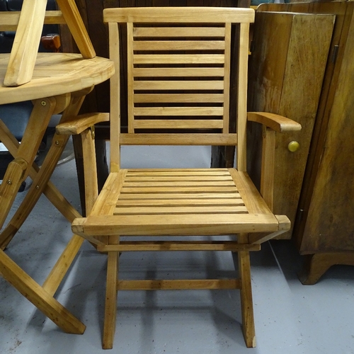 1827 - A teak circular folding garden table, and a pair of matching folding teak chairs