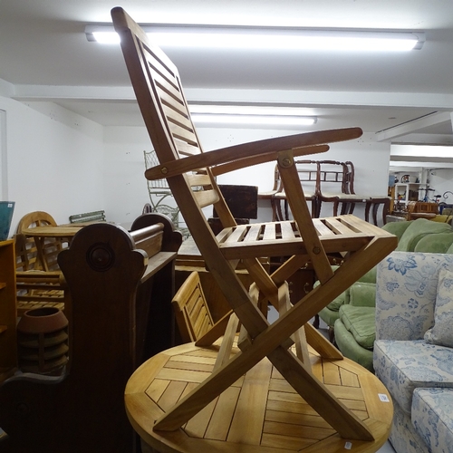 1827 - A teak circular folding garden table, and a pair of matching folding teak chairs