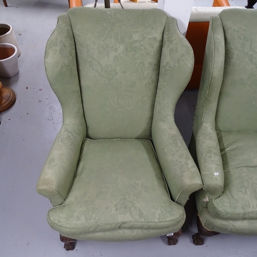 1829 - A pair of Edwardian upholstered wingback fireside armchairs, on carved cabriole legs, with hoof feet