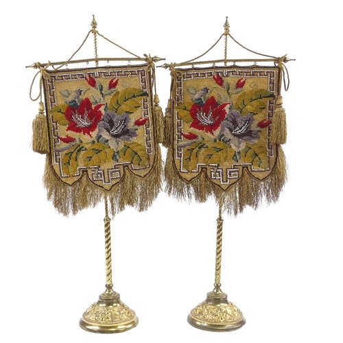 397 - A pair of 19th century Berlin beadwork face screens, mounted on original gilt-brass stands on relief... 