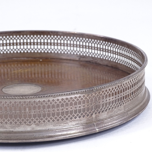 104 - A circular mahogany and silver drinks tray, with pierced gallery, London 1973, diameter 26cm