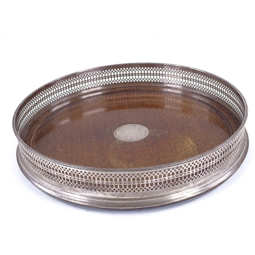 104 - A circular mahogany and silver drinks tray, with pierced gallery, London 1973, diameter 26cm