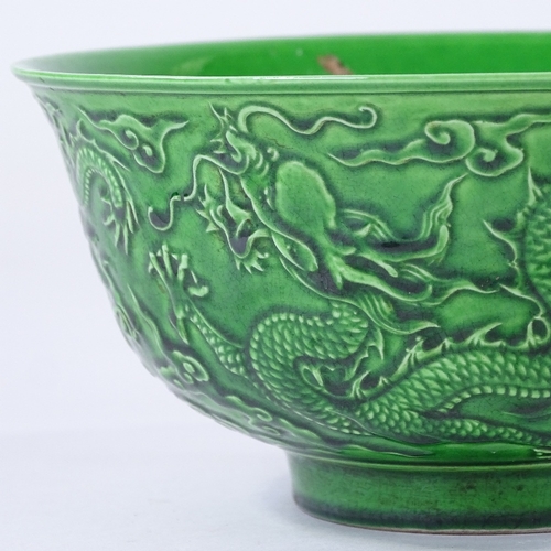 137 - A Chinese green glaze porcelain bowl, with relief moulded dragons, 6 character mark, diameter 16cm