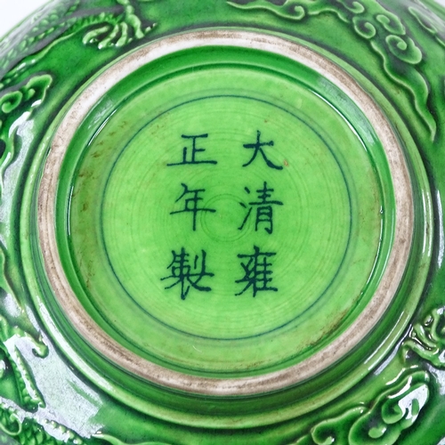 137 - A Chinese green glaze porcelain bowl, with relief moulded dragons, 6 character mark, diameter 16cm