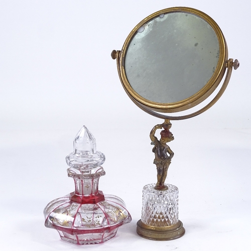 152 - A gilt-bronze and cut-glass shaving mirror, with Classical cherub support, and a cranberry overlay c... 